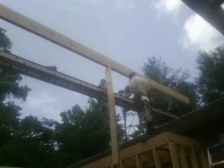 Carpenter setting a ridge beam over a new addition frame — Ice Dam Removal by Roofing Brothers in San Miguel