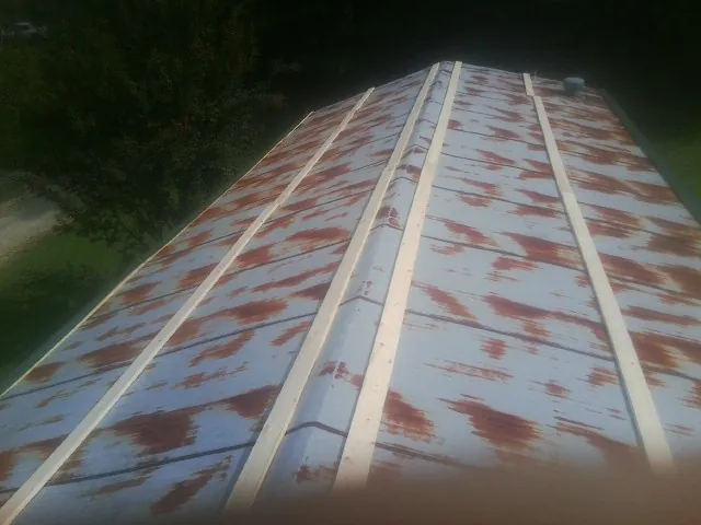 Rusted metal roof panels with new wood purlins before replacement — Storm Damage Roof Repair in San Miguel by Roofing Brothers