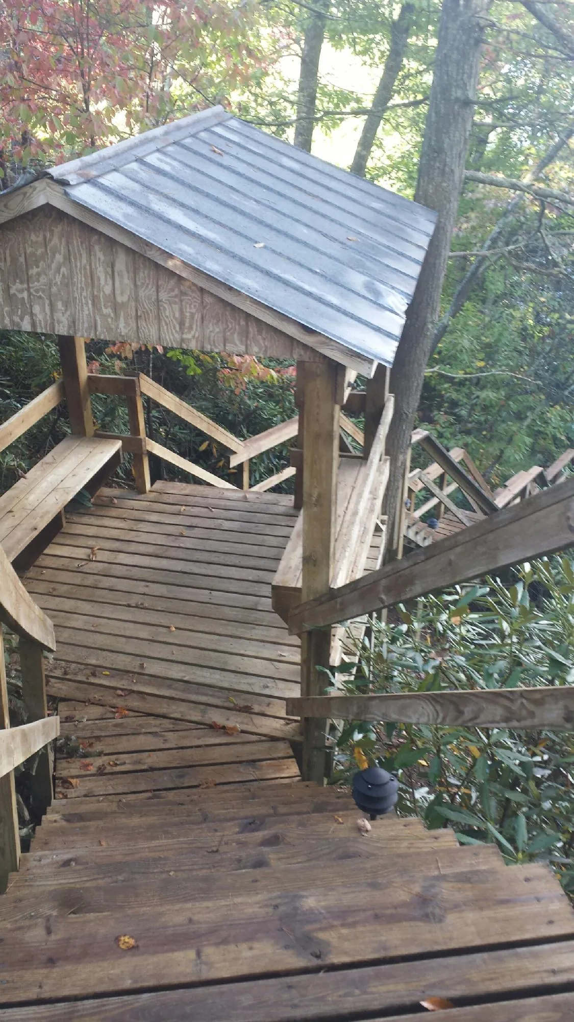 Metal roofed shelter over wooden steps on a wooded walkway — Skylight Repair & Installation work by our crew in San Miguel