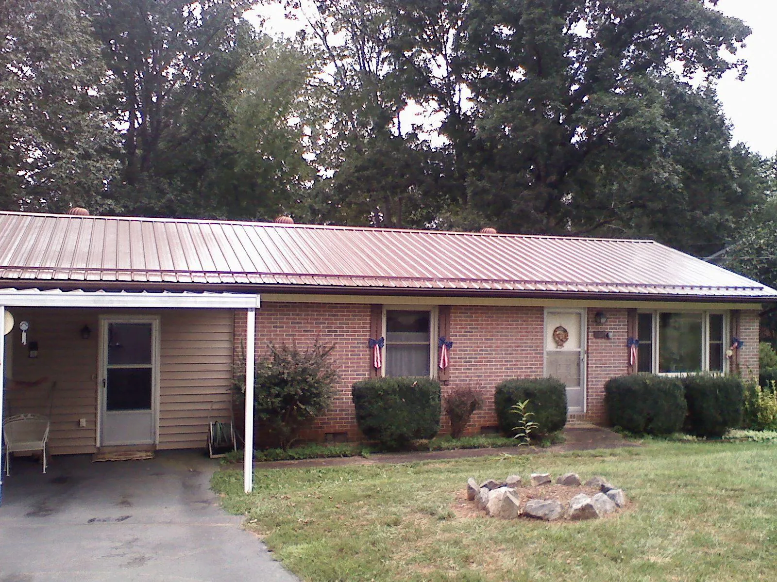 Bronze metal roof and carport on a brick ranch home — Roof Repair work by our crew in San Miguel