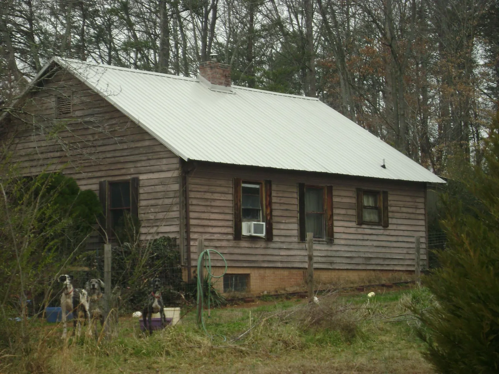 White metal roof on an old wood sided farmhouse, from a Metal Roof Installation job in San Miguel